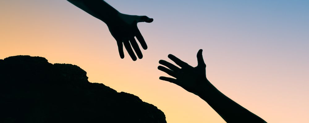 Silhouette of two hands reaching for each other